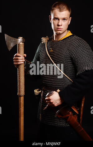 Homme guerrier en armure médiévale et chain mail, Viking avec hache dans les mains . Banque D'Images