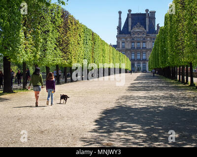 PARIS, FRANCE - 5 mai 2016 : deux femmes avec un chien marche sur une avenue dans le jardin des Tuileries Banque D'Images