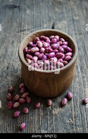 Sèche-beens grains violet dans un bol sur la table en bois rustique. Haricot source de protéines végétaliennes. Alimentation saine. Banque D'Images