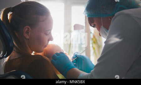 Petite fille à la réception chez le dentiste, le nettoyage et l'arrosage stomatologist les dents de l'enfant, girl smiling Banque D'Images