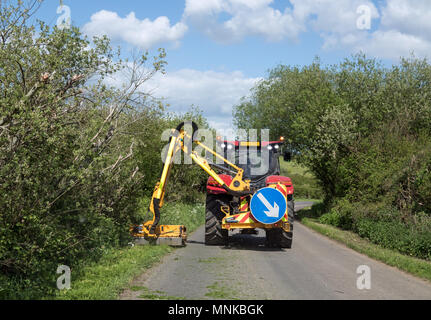 Verges d'herbe coupée par la tondeuse grand tracteur à Sussex country lane au printemps. Banque D'Images