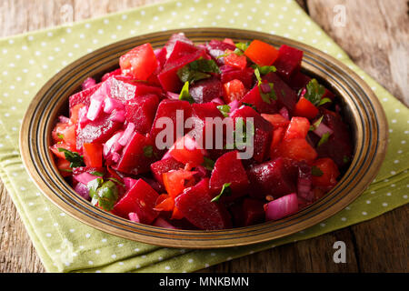 Savoureuse salade marocaine alimentaires à partir de betteraves cuites avec oignons, tomates et fines herbes avec l'huile d'olive sur une plaque sur une table horizontale. Banque D'Images