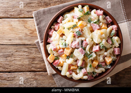 Nourriture hawaïenne : salade de pâtes, jambon, ananas, oignons, fromage cheddar, close-up avec de la mayonnaise dans un bol sur la table. haut horizontale Vue de dessus Banque D'Images