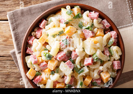 Salade de pâtes avec Hawaiian copieux, jambon, ananas, oignons, fromage cheddar habillés avec de la mayonnaise close-up dans un bol sur la table horizontale f Vue de dessus. Banque D'Images