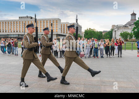 Regardé par les passants par une garde d'honneur marche vers la tombe du Soldat inconnu sur la place Pilsudski à Varsovie, Pologne. Banque D'Images