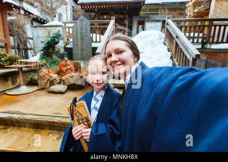 Famille de mère et fille portant un yukata kimono traditionnel japonais faisant de la rue à selfies onsen resort ville au Japon. Banque D'Images