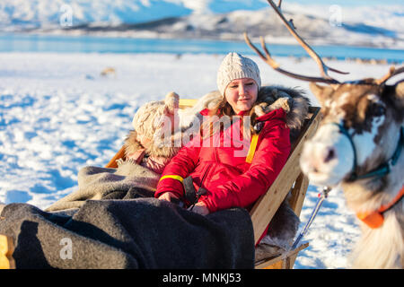 Mère de famille et sa fille à reindeer safari sur journée d'hiver ensoleillée dans le Nord de la Norvège Banque D'Images