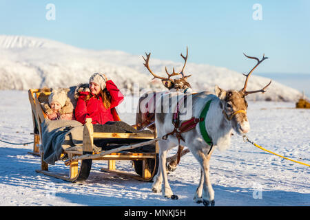 Mère de famille et sa fille à reindeer safari sur journée d'hiver ensoleillée dans le Nord de la Norvège Banque D'Images