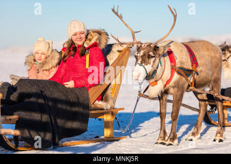 Mère de famille et sa fille à reindeer safari sur journée d'hiver ensoleillée dans le Nord de la Norvège Banque D'Images