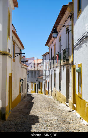 L'avis de rue étroite pavée d'Evora avec l'ambiance des maisons blanches. Evora. L'Alentejo. Portugal Banque D'Images