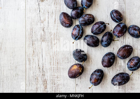 Damson Plum sur la surface en bois blanc. Les aliments biologiques concept. Banque D'Images