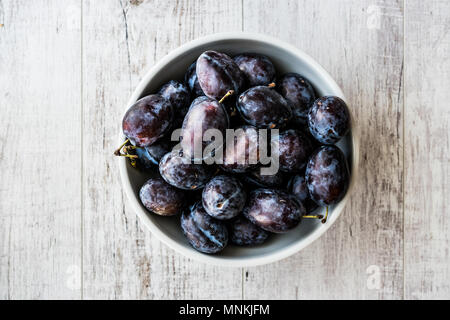 Damson Plum sur la surface en bois blanc. Les aliments biologiques concept. Banque D'Images