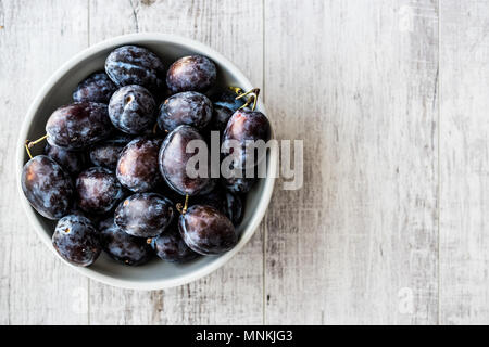 Damson Plum sur la surface en bois blanc. Les aliments biologiques concept. Banque D'Images