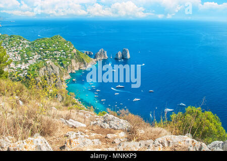 Belle vue de la ville de Capri et les bateaux autour de rochers Faraglioni du haut du mont Solaro, aux beaux jours de l'été, Capri, Italie Banque D'Images