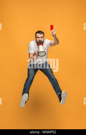 Supporter de football avec carte rouge sur fond orange Banque D'Images