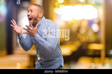 African American man with beard stressant laissant les mains sur la tête, terrifié, en panique, des cris dans la nuit Banque D'Images