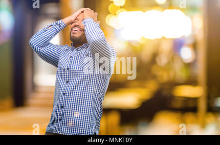 African American man with beard stressant laissant les mains sur la tête, fatigué et frustré de nuit Banque D'Images