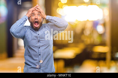 African American man with beard stressant laissant les mains sur la tête, terrifié, en panique, des cris dans la nuit Banque D'Images