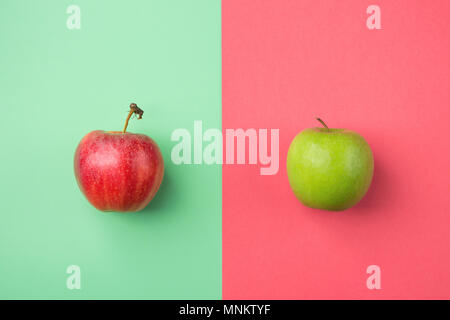 Les pommes biologiques mûrs sur Split Duotone vert rouge sur fond rose cerise. Titre image créative. Les vitamines de l'été la mode Vegan Concept. Avec l'affiche de l'alimentation Banque D'Images