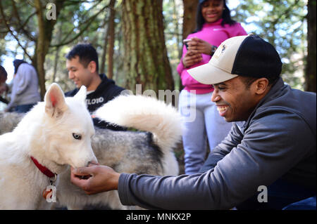 PORT Orchard, Washington (10 mars 2018) l'Aviation aviateur Ordnanceman Justin de Jacksonville en Floride, Elliot prend une pause pour interagir avec un chien pendant une coalition de marins contre les décisions destructrices (CSADD) sortie de service communautaire pour les marins affectés au porte-avions USS Nimitz (CVN 68), le 10 mars 2018. Les marins CSADD promouvoir des choix positifs et développer le leadership en organisant les réseaux sociaux locaux, facilitant les discussions, en produisant des messages visuels, la promotion de la participation communautaire et l'accueil des activités de loisirs. Nimitz est la réalisation d'une disponibilité progressive prévue d Banque D'Images