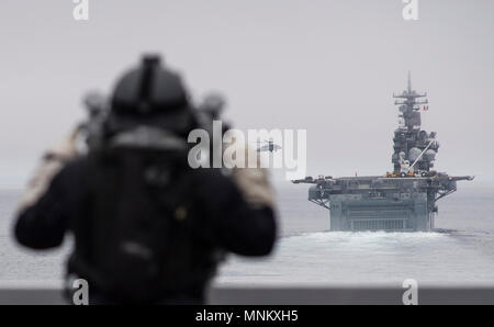 Océan Pacifique (le 13 mars 2018) du pont de la San Antonio-classe de transport amphibie USS dock Anchorage (LPD 23), 3ème classe Technicien en électronique Colin C. Robinson, de Philadelphie, Pennsylvanie, observe les opérations aériennes sur le Wasp-classe d'assaut amphibie USS Essex (DG 2) au cours de la simulation d'un exercice d'entraînement de transit du détroit. Anchorage est en cours avec d'autres navires de la Essex Groupe amphibie (ARG) dans la Marine's premier ARG Surface Warfare Advanced Tactical Training (SWATT) de l'exercice. Bad tripes est dirigé par le Naval Surface et Centre de développement de la guerre des mines (SMWDC) et conception est Banque D'Images