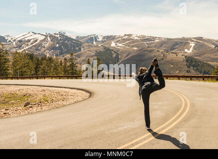 African American Woman performing a yoga pose dans les montagnes de Deer Valley Ski Resorts dans la région de Park City, Salt Lake City à l'extérieur au printemps. Banque D'Images