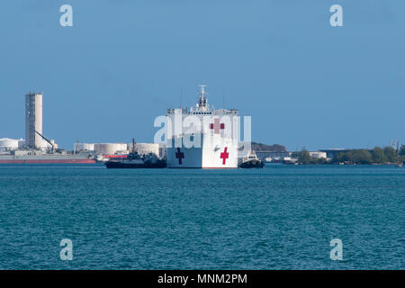 NAVAL BASE GUAM (17 mars 2018) grand port militaire de la commande de transport maritime guide remorqueurs navire-hôpital USNS Mercy (T-AH 19) comme le navire tire en base navale américaine de Guam à l'appui de Partenariat du Pacifique 2018 (PP 18). PP18's mission est de travailler ensemble avec l'hôte et les pays partenaires à améliorer l'interopérabilité régionale et de capacités de réaction aux catastrophes, d'accroître la stabilité et la sécurité dans la région, et de favoriser de nouvelles amitiés et durable dans toute la région Indo-Pacifique. Partenariat du Pacifique, maintenant dans sa 13e version, est la plus grande multinationale annuelle l'aide humanitaire et secours en cas de préparer Banque D'Images