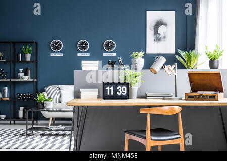 Salon bleu foncé avec l'intérieur des racks industriels noir et élégant espace de travail par un demi-mur gris Banque D'Images