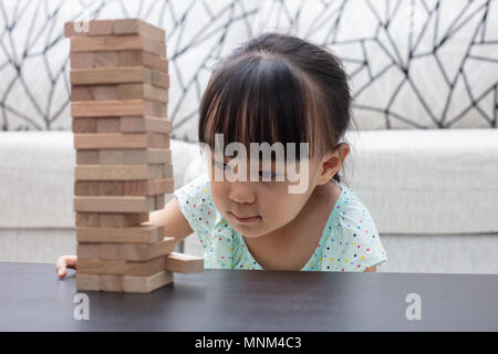 Chinois asiatique petite fille jouant à la maison piles en bois Banque D'Images