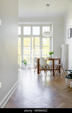 Chaises en bois blanc à table dans la grande salle à manger de l'intérieur avec fenêtre. Photo réelle Banque D'Images