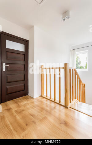 Accueil couloir avec portes et escalier en bois marron avec balustrade simple Banque D'Images