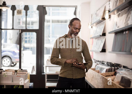 Propriétaire de petite entreprise à l'aide de tablette numérique dans un magasin de disques Banque D'Images