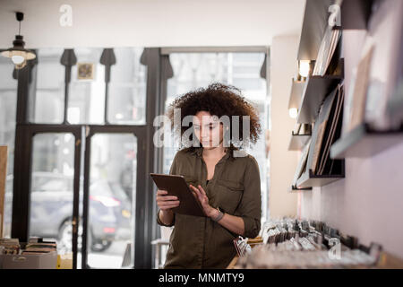 Propriétaire de petite entreprise à l'aide de tablette numérique dans un magasin de disques Banque D'Images