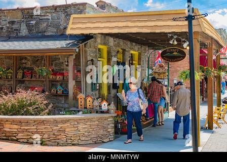 Les touristes passer le coucher du soleil Tee's & Hattery boutique sur la rue Main à Blowing Rock, NC, USA. Banque D'Images