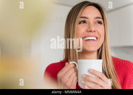 Portrait of smiling young woman holding mug Banque D'Images