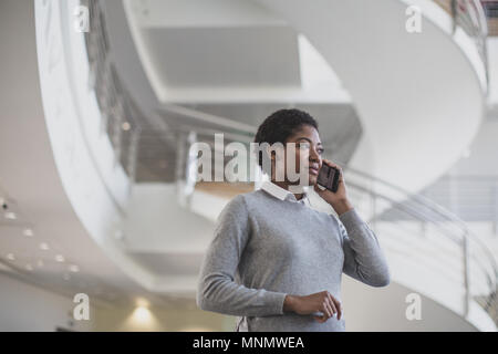 African American using smartphone in modern office Banque D'Images