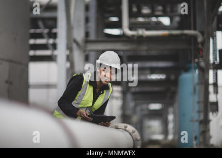 Femme travailleur industriel, contrôle de pipe-line Banque D'Images