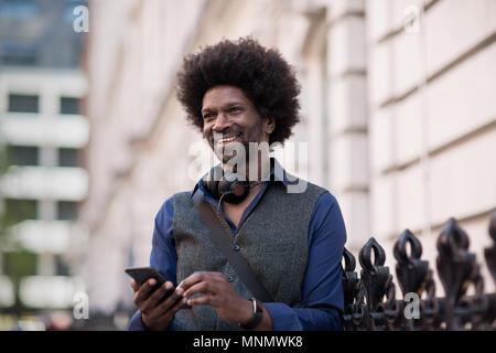 African American male en utilisant smartphone outdoors Banque D'Images