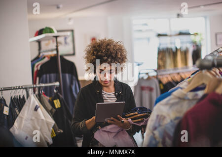 Store manager using digital tablet in a clothing store Banque D'Images