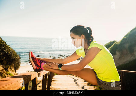États-unis, Californie, Newport Beach, Woman stretching on beach Banque D'Images