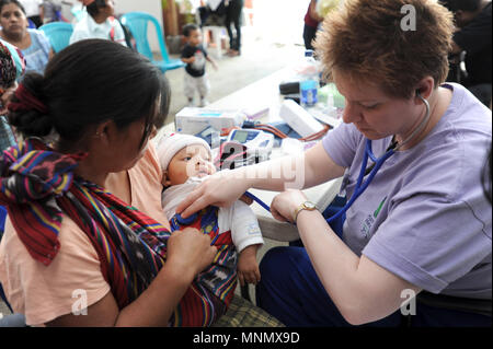 Une infirmière examine l'enfant autochtone maya à clinique gratuite fournie par NPO à Panajachel, Solola, Guatemala. Banque D'Images