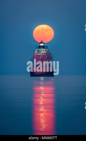 Un plein, super lune se lève derrière le phare de Sandy Point, sur la baie de Chesapeake, près de l'Annapolis, Maryland. Banque D'Images