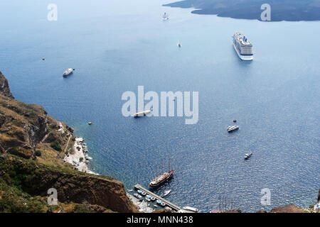 Une vue de dessus de la grands et petits navires dans la baie de l'île volcanique de Santorin, Grèce. Banque D'Images