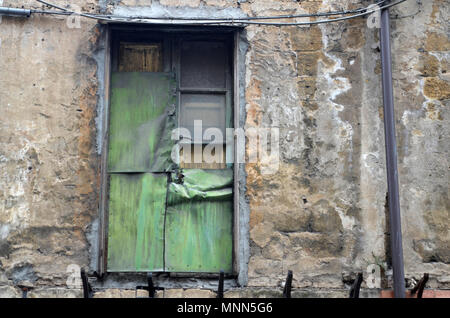 Une fenêtre sur un vieux bâtiment à Palerme, Sicile, c'est été fermés et couverts de métal vert Banque D'Images