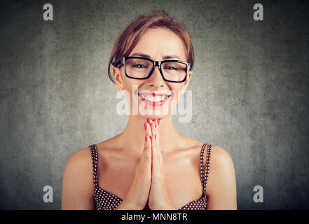 Portrait d'une jolie femme avec des paumes de main, a un visage heureux d'expression, de demander à quelqu'un une faveur. Jolie jolie femme fait demande, plaide fo Banque D'Images