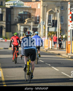 Les coureurs et cyclistes traversant le barrage de Cardiff Bay in early morning light Banque D'Images