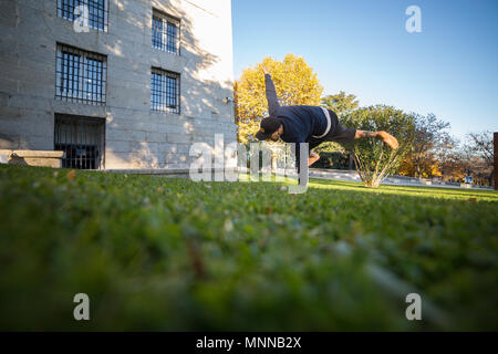Jeune homme faisant un incroyable tour de parkour dans le parc. Banque D'Images