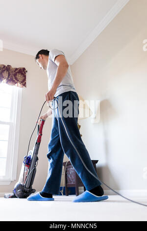 Jeune homme chambre mari papa reste à la maison à l'aide de l'aspirateur à vide sur la moquette à l'intérieur de l'intérieur de chambre salle de séjour par fenêtre, debout autour de sl Banque D'Images