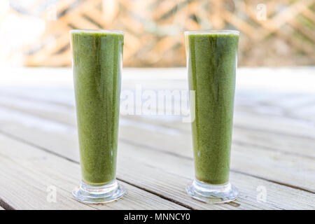 Libre de deux grands smoothies aux fruits légumes verts couple paire de lunettes à l'extérieur de l'extérieur, sur une terrasse en bois pour déjeuner végétalien premières sain Banque D'Images