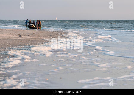 Naples, États-Unis - 29 Avril 2018 : Libre de mousse sur l'autre au cours de la marée rouge d'algues toxique Beach en Floride Golfe du Mexique pendant le coucher du soleil sur le sable Banque D'Images